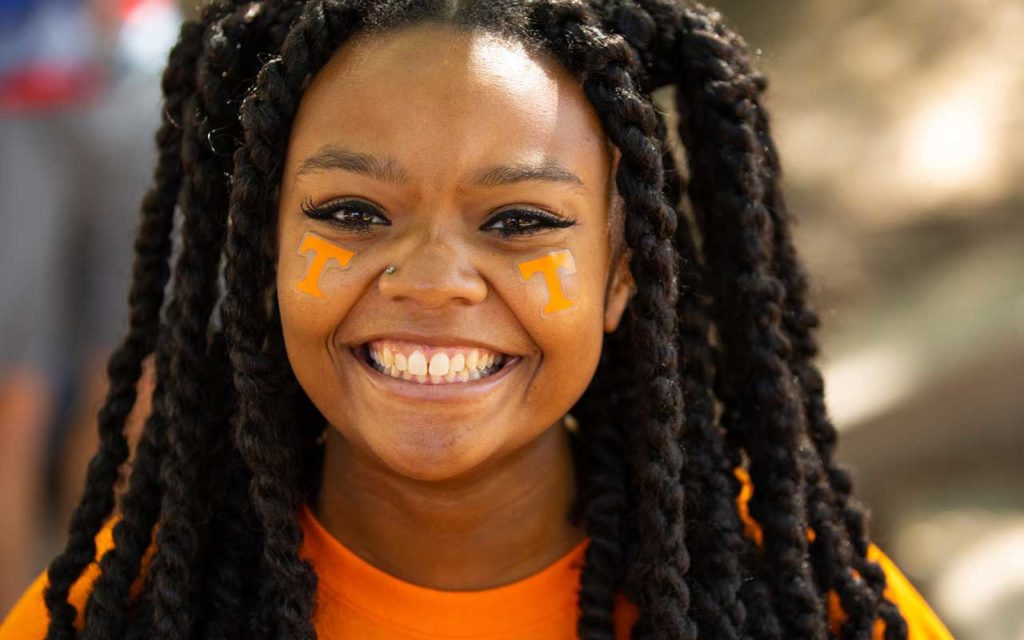 close up of black woman smiling with a power t painted on each cheek