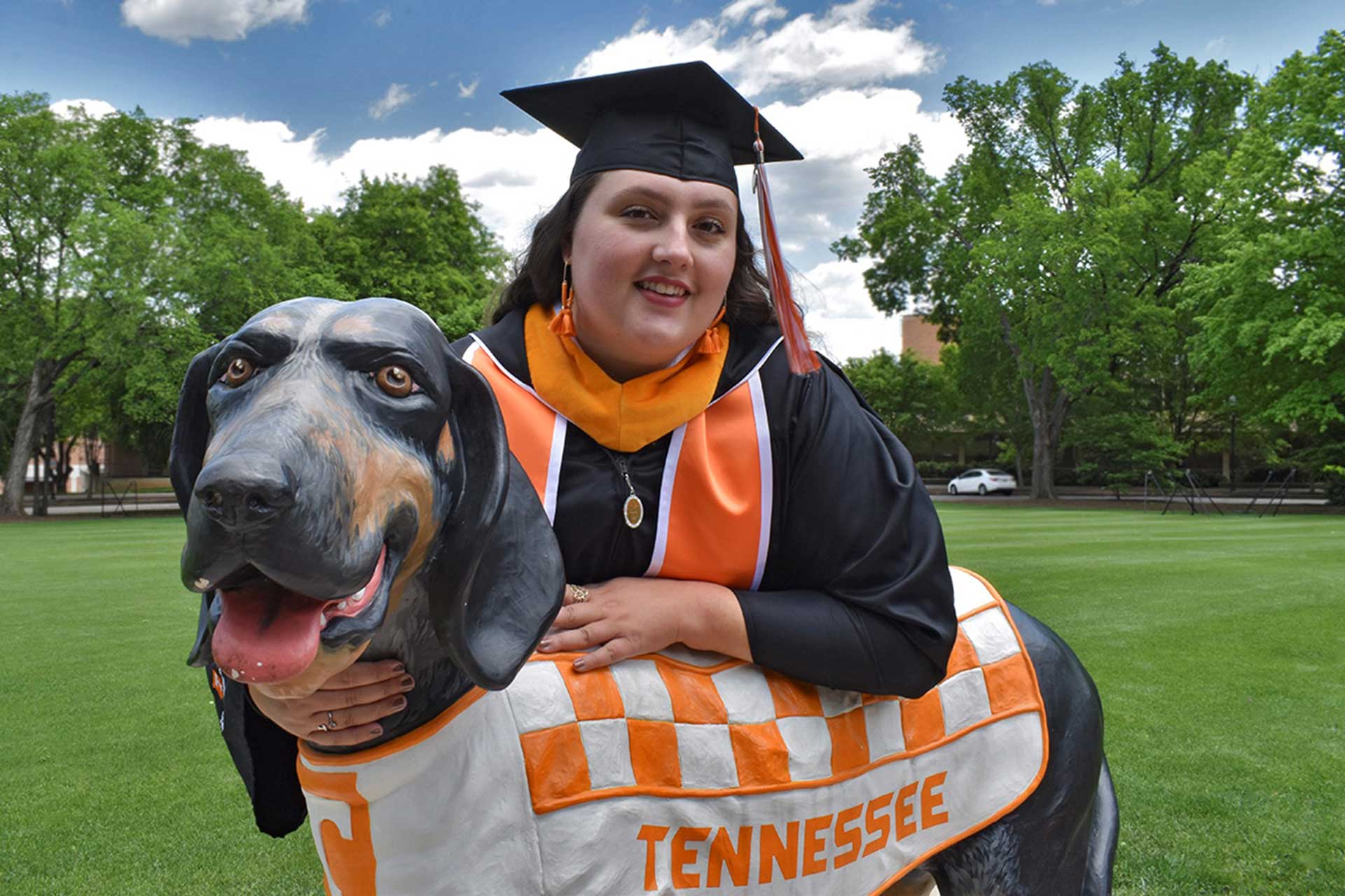 online graduate Ciera Noe hugging smokey dog statue