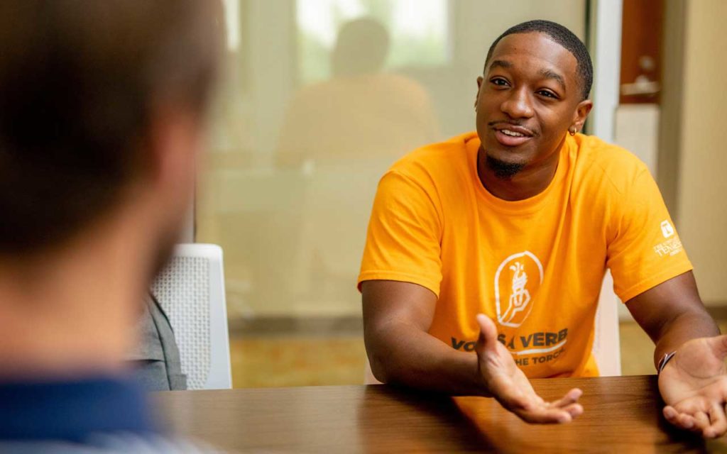 young black male sitting at table talking with employer