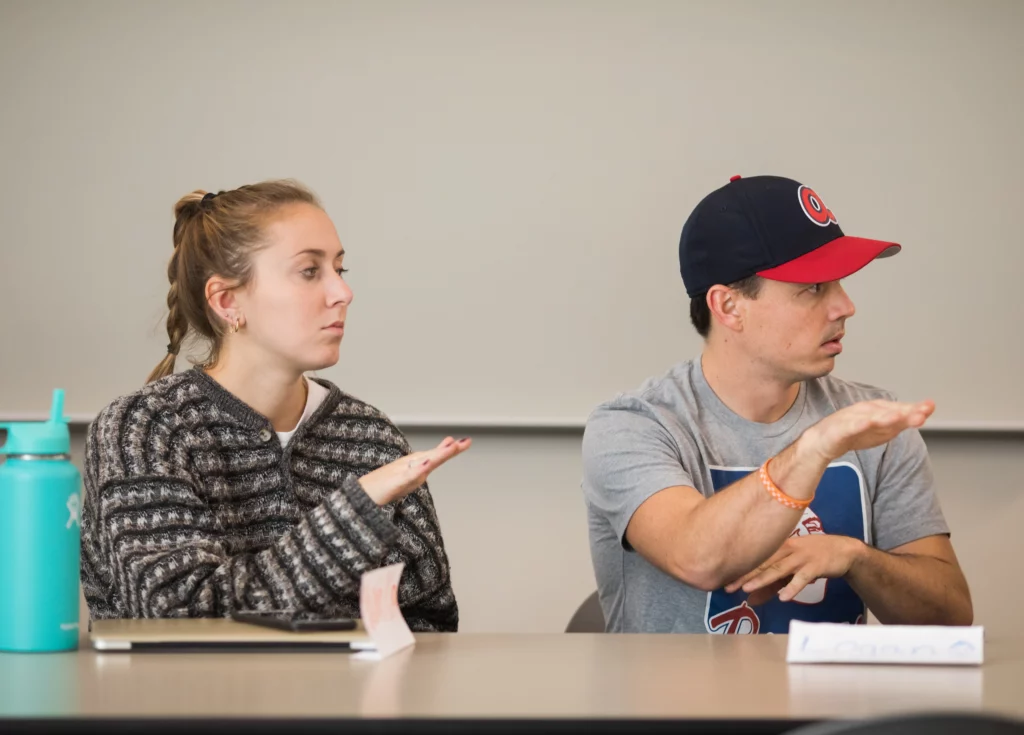 two students practicing American sign language