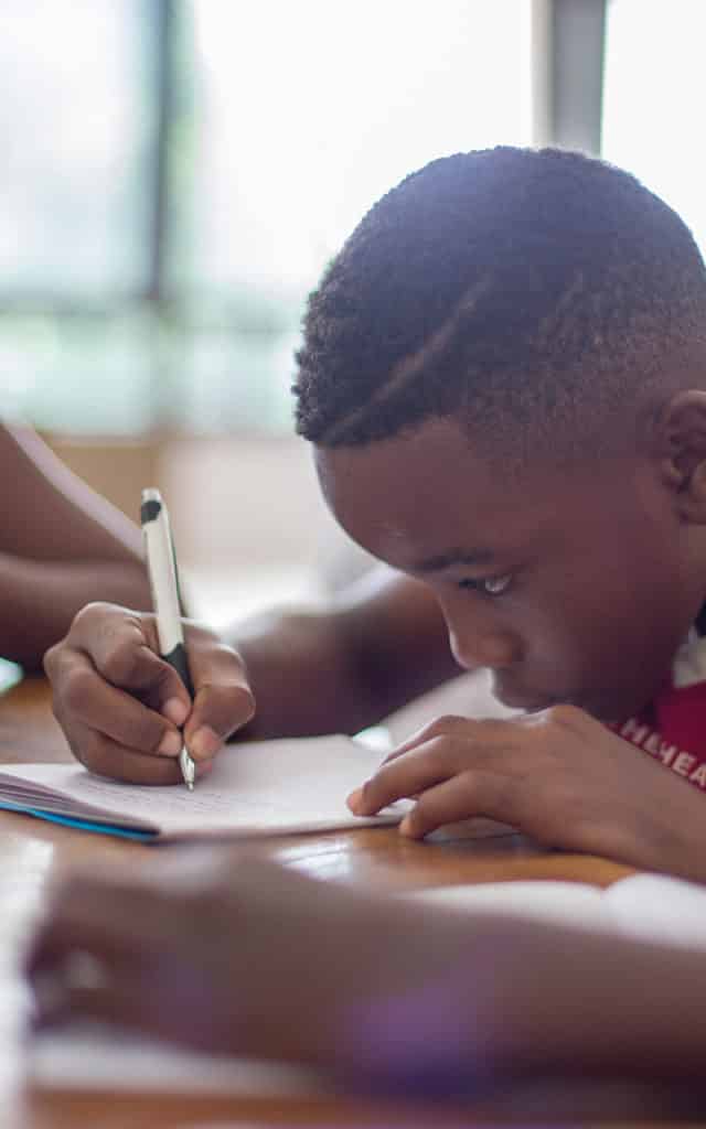 young black elementary student practicing his writing 