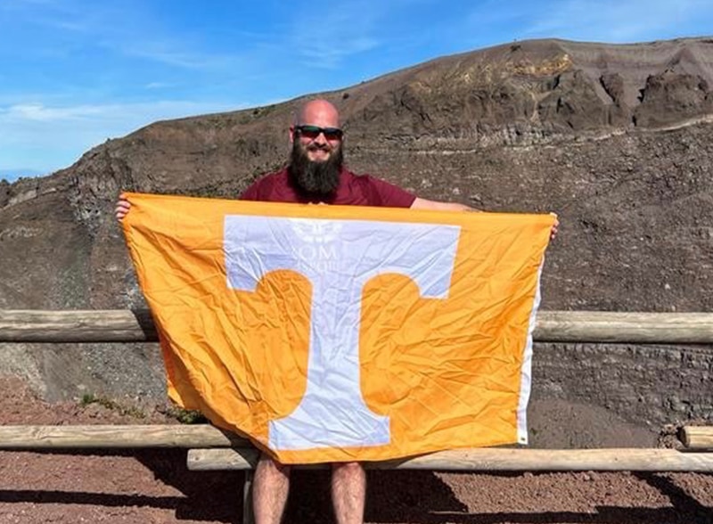 online student Nathan Vann holding orange Tennessee flag